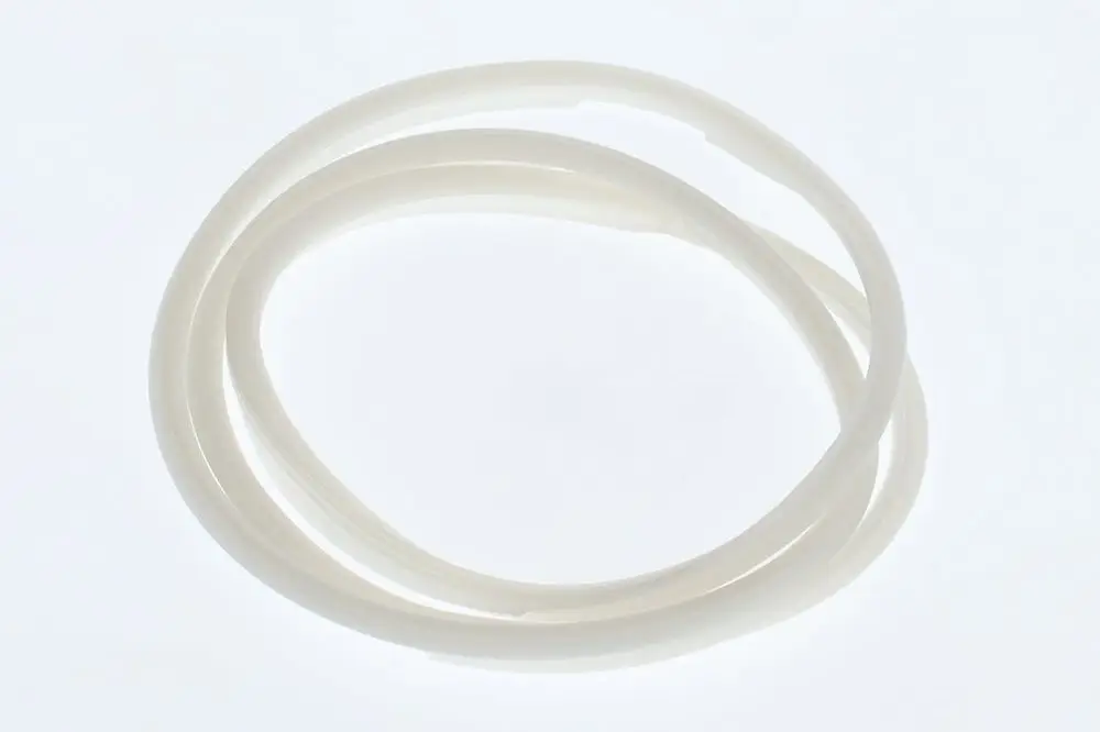 Zwei weiße Dichtungen aus flexiblem Material, passend für einen Kondenswassersammler, möglicherweise von Bosch, liegen auf hellem Hintergrund.